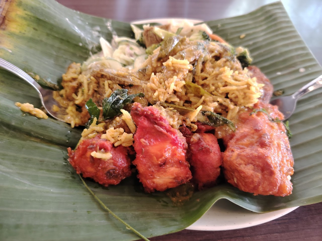 Nasi briyani with fried chicken on banana leaf