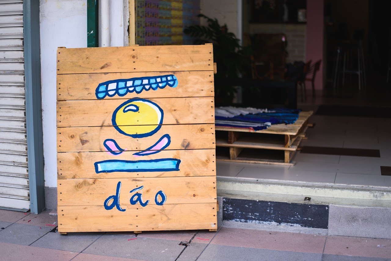 The dáo bowl-and-spoon logomark hand-painted on wood outside the shop