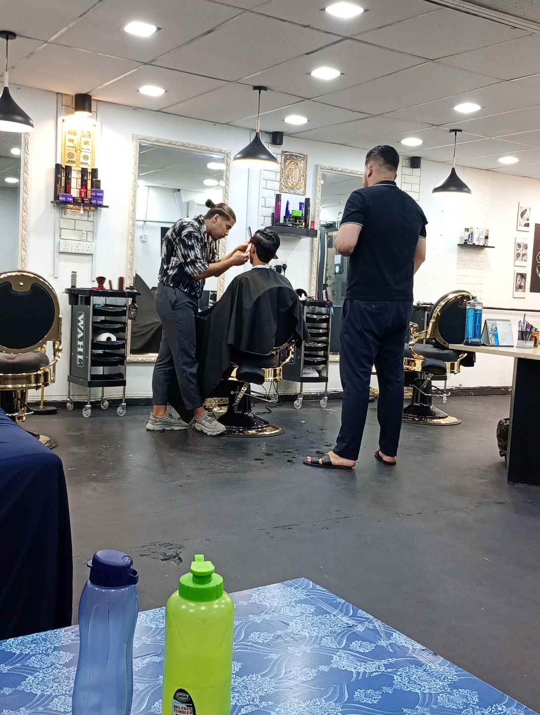 Barber mid-fade on a seated customer at MD Hilmi Barber Shop