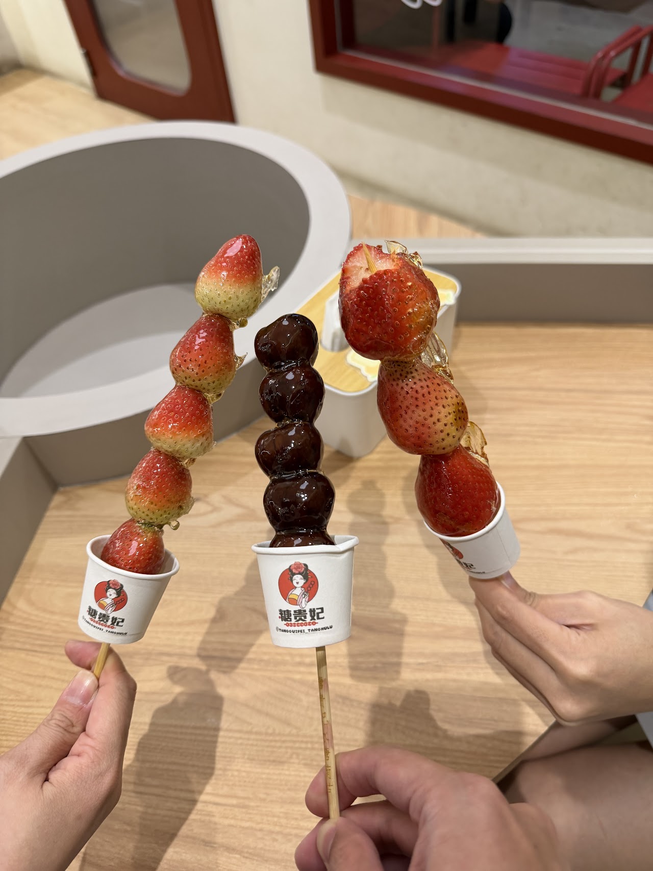 Strawberry and grape tanghulu skewers held up